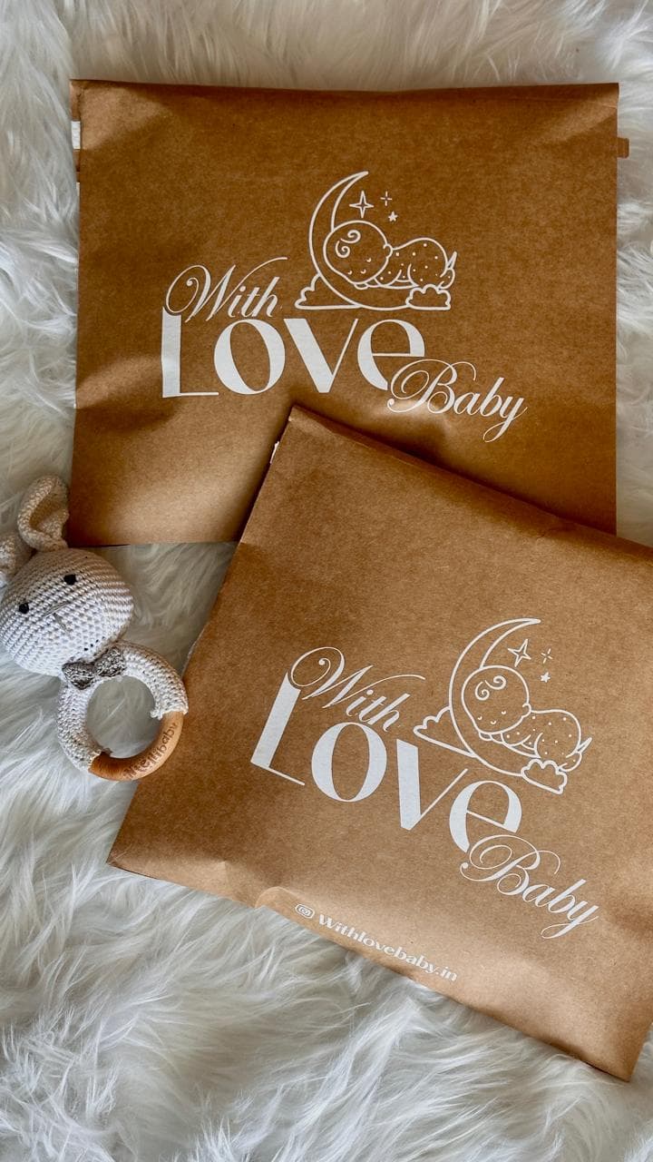 With Love Baby branded kraft packaging with a crochet rattle toy