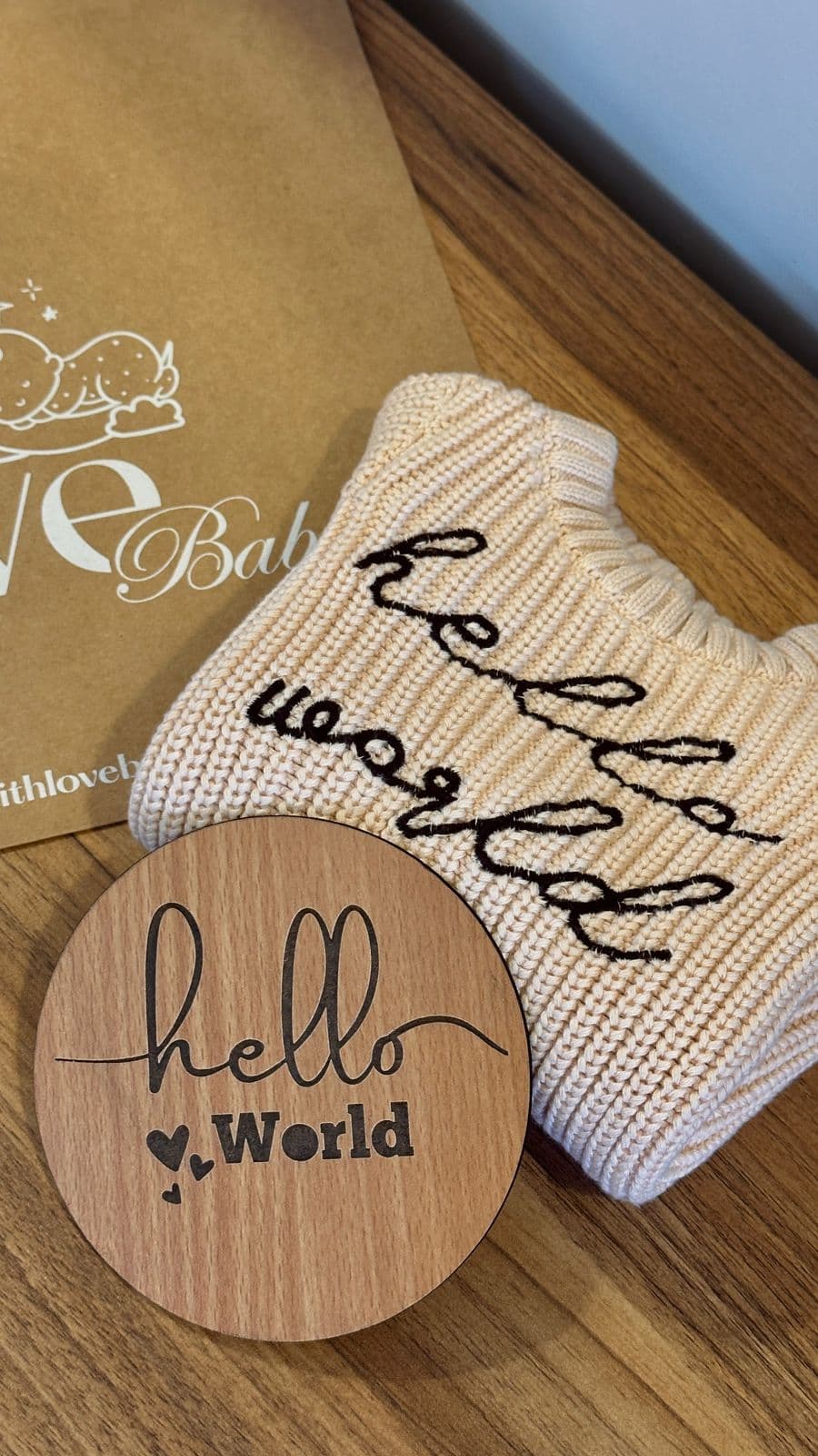 Hello World romper with wooden plaque and With Love Baby packaging