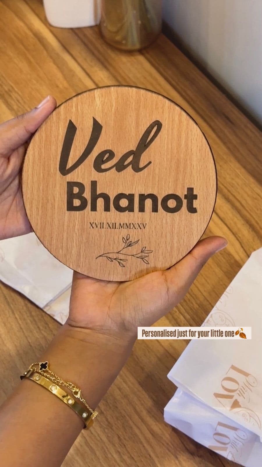 Round wooden name plaque with Ved Bhanot engraved, held in hand